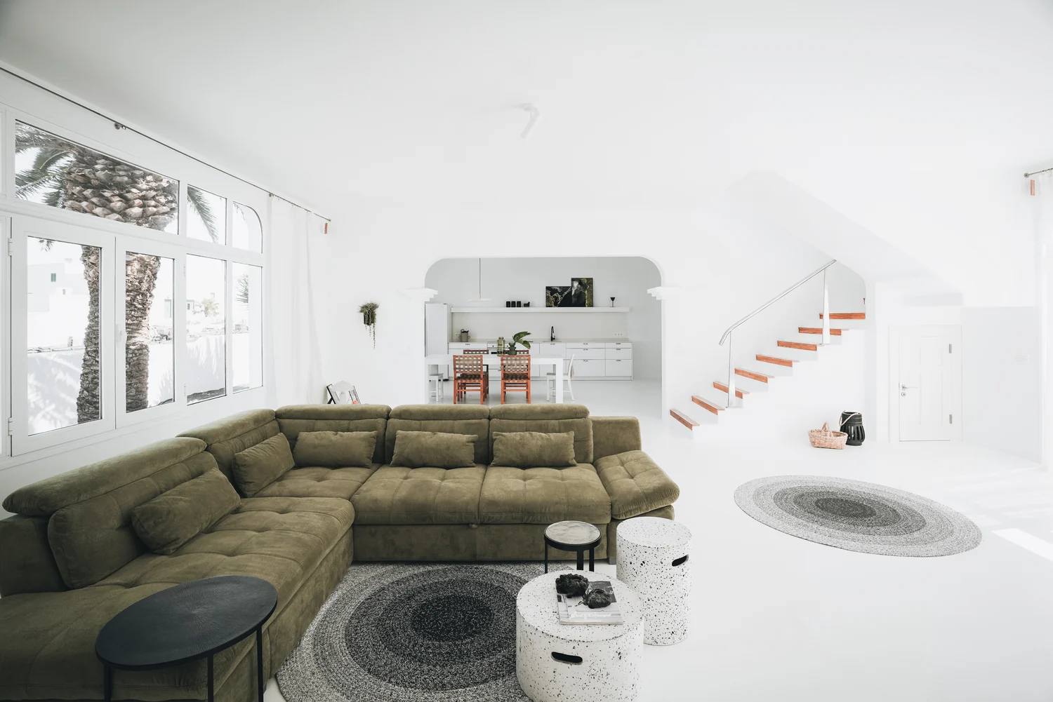Amonita’s living room with an olive-green sofa and white arched openings